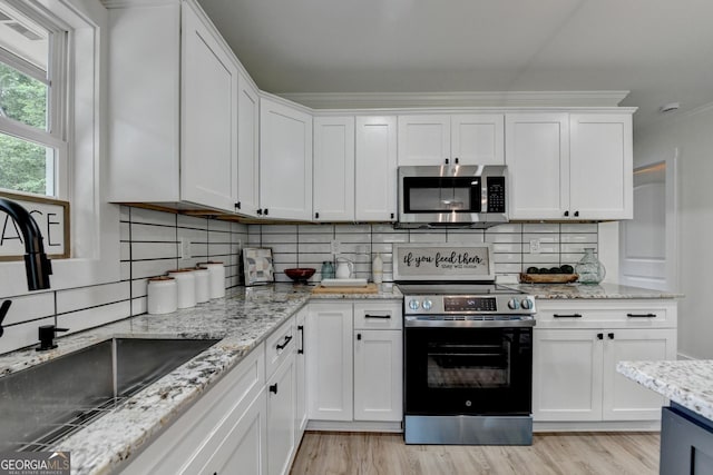 5371 Wg Robinson Rd, Gainesville, GA 30506 - kitchen with appliances with stainless steel finishes, light wood-style flooring, white cabinets, and crown molding