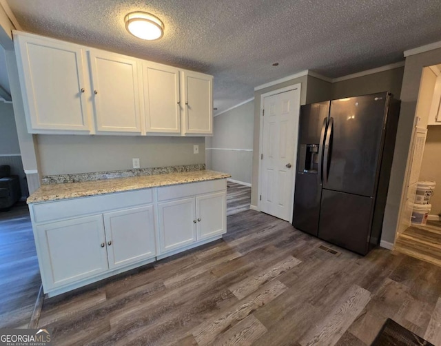 50 E College St, Royston, GA 30662 - kitchen with fridge with ice dispenser, white cabinets, dark wood-type flooring, a textured ceiling, and light stone countertops