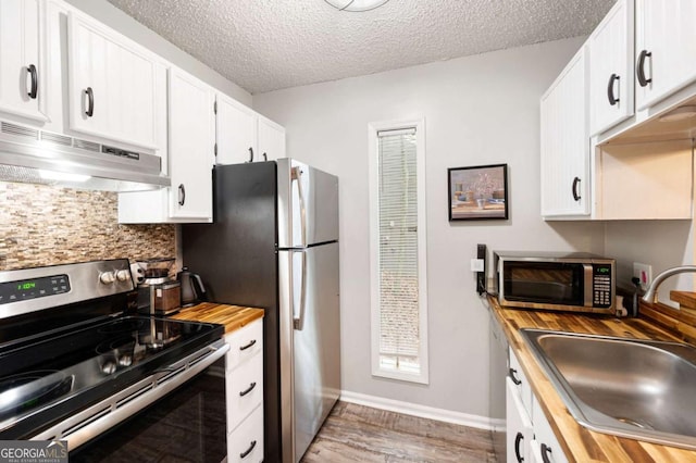 140 Indian Ridge Ct, Waleska, GA 30183 - kitchen featuring stainless steel appliances, under cabinet range hood, wooden counters, decorative backsplash, and white cabinetry