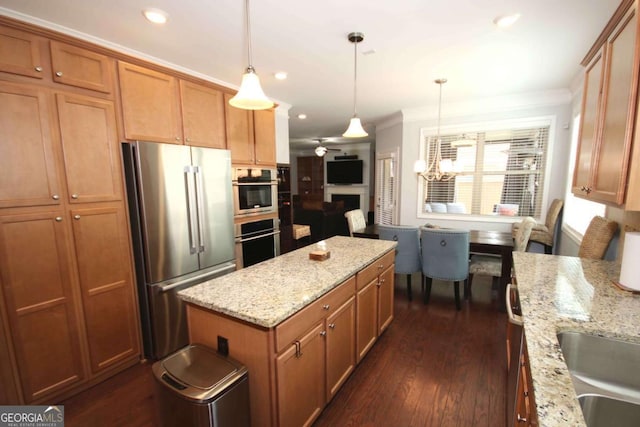 2311 Arnold Palmer Way, Duluth, GA 30096 - kitchen with stainless steel appliances, crown molding, brown cabinetry, a kitchen island, and dark wood finished floors