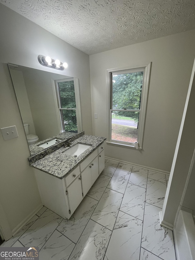 56 Ridgewood Ct, Mcdonough, GA 30252 - bathroom featuring vanity, marble finish floors, plenty of natural light, and a textured ceiling