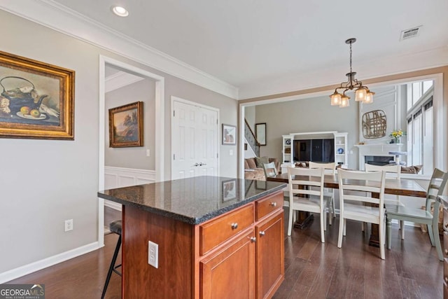 610 Syemore Pass, Canton, GA 30115 - kitchen with a chandelier, dark wood-style floors, crown molding, a breakfast bar area, and brown cabinets