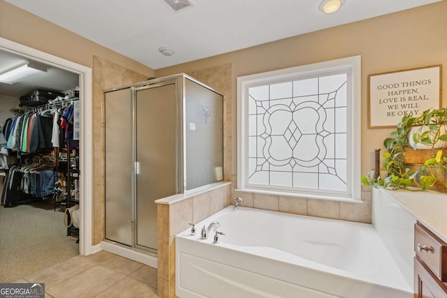 610 Syemore Pass, Canton, GA 30115 - full bath featuring a shower stall, a garden tub, a walk in closet, tile patterned flooring, and healthy amount of natural light