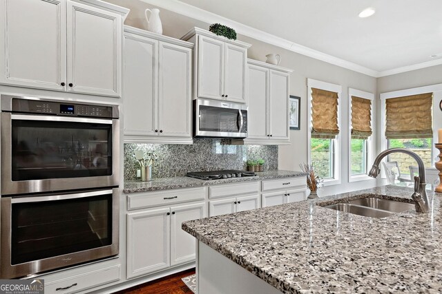 406 Horizon Trl, Canton, GA 30114 - kitchen featuring stainless steel appliances, ornamental molding, white cabinetry, light stone counters, and backsplash
