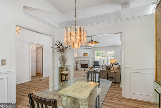 14 Winter Ln, Newnan, GA 30265 - dining space featuring light wood-style flooring, a chandelier, and a fireplace