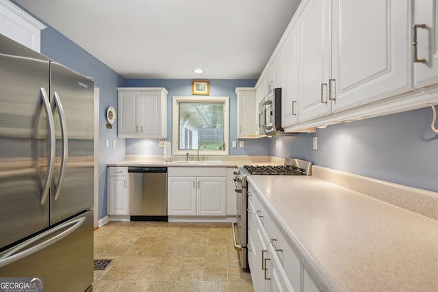 2790 Laurel Ridge Dr, Decatur, GA 30033 - kitchen with appliances with stainless steel finishes, recessed lighting, white cabinetry, light countertops, and stone finish flooring