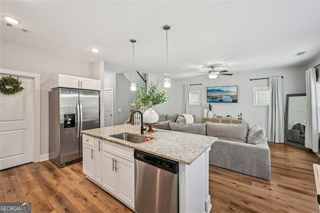 5 Towne Villas Dr, Jasper, GA 30143 - kitchen featuring appliances with stainless steel finishes, white cabinetry, pendant lighting, light stone countertops, and a kitchen island with sink
