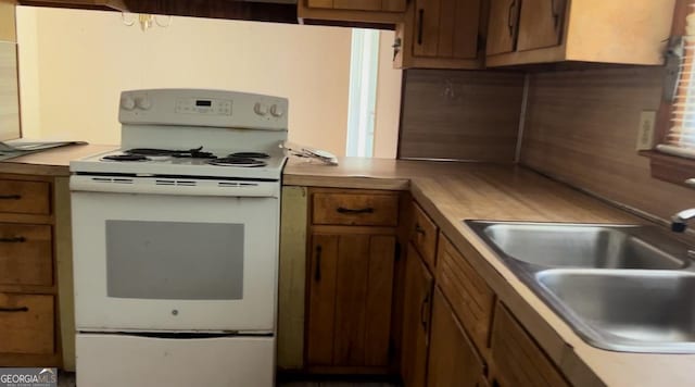 6521 Menlo Way, Rex, GA 30273 - kitchen featuring white electric range, brown cabinets, and light countertops