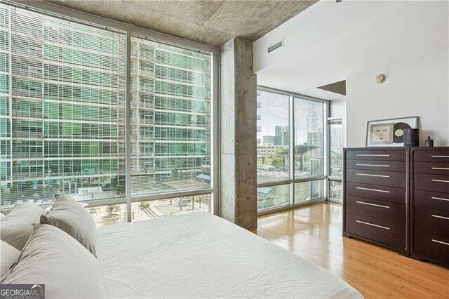943 Peachtree St NE Unit 902, Atlanta, GA 30309 - bedroom featuring a wall of windows and light wood finished floors
