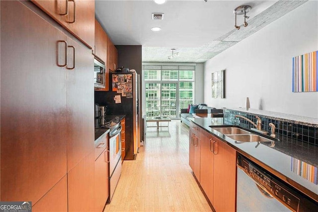 943 Peachtree St NE Unit 902, Atlanta, GA 30309 - kitchen featuring stainless steel appliances, light wood-style floors, dark countertops, open floor plan, and recessed lighting