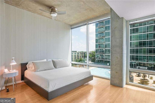943 Peachtree St NE Unit 902, Atlanta, GA 30309 - bedroom with floor to ceiling windows, wood finished floors, and a ceiling fan