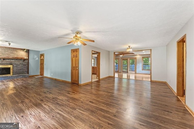 137 Trickum Hills Dr, Woodstock, GA 30188 - unfurnished living room featuring ceiling fan, wood finished floors, a textured ceiling, and a brick fireplace