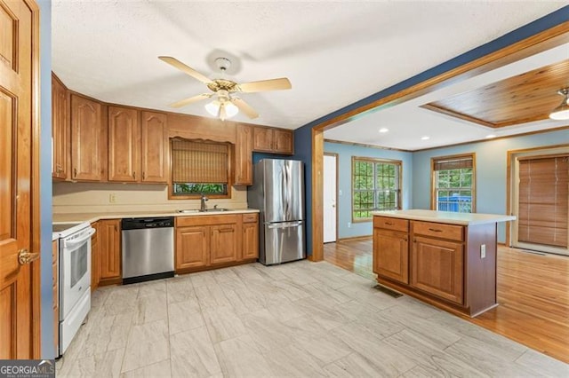 137 Trickum Hills Dr, Woodstock, GA 30188 - kitchen with stainless steel appliances, light countertops, brown cabinets, ceiling fan, and crown molding