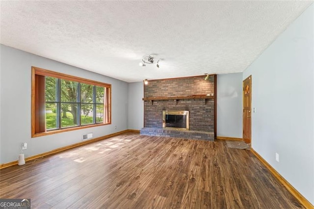 137 Trickum Hills Dr, Woodstock, GA 30188 - unfurnished living room with wood finished floors, a textured ceiling, and a fireplace