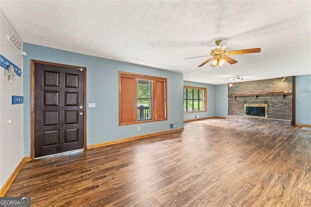 137 Trickum Hills Dr, Woodstock, GA 30188 - unfurnished living room with a textured ceiling, wood finished floors, a ceiling fan, and a brick fireplace