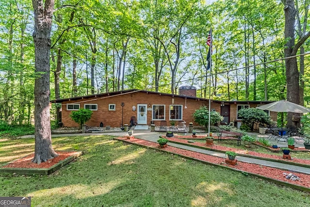 1813 Freeman Rd, Jonesboro, GA 30236 - rear view of house featuring a chimney, brick siding, a yard, and a patio