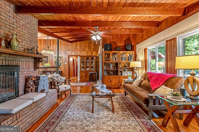 1813 Freeman Rd, Jonesboro, GA 30236 - living room with hardwood / wood-style floors, a wooden ceiling with exposed beams, a brick fireplace, wooden walls, and a ceiling fan