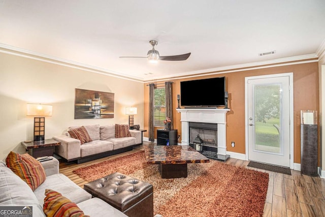 2437 Charleston Pointe Ct SE, Atlanta, GA 30316 - living room featuring crown molding, a ceiling fan, wood finished floors, a fireplace with raised hearth, and healthy amount of natural light