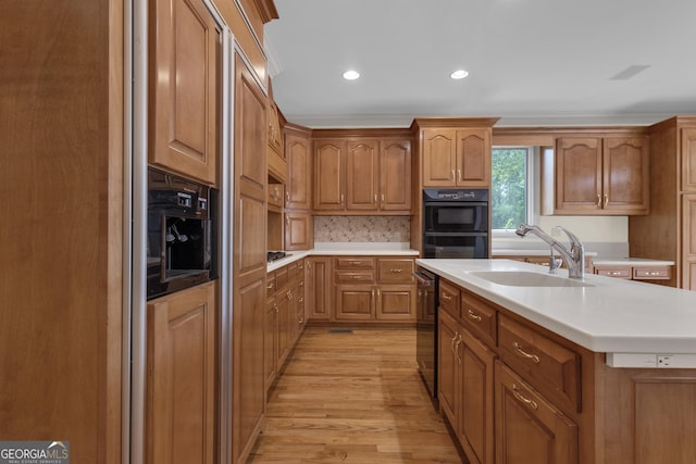 821 Carnellian Ln, Peachtree City, GA 30269 - kitchen with light wood finished floors, light countertops, recessed lighting, a center island with sink, and brown cabinetry