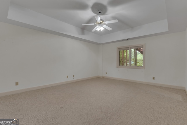 821 Carnellian Ln, Peachtree City, GA 30269 - empty room featuring a tray ceiling, ceiling fan, and light colored carpet