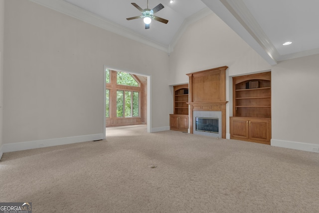821 Carnellian Ln, Peachtree City, GA 30269 - unfurnished living room featuring ornamental molding, ceiling fan, high vaulted ceiling, a tiled fireplace, and light carpet