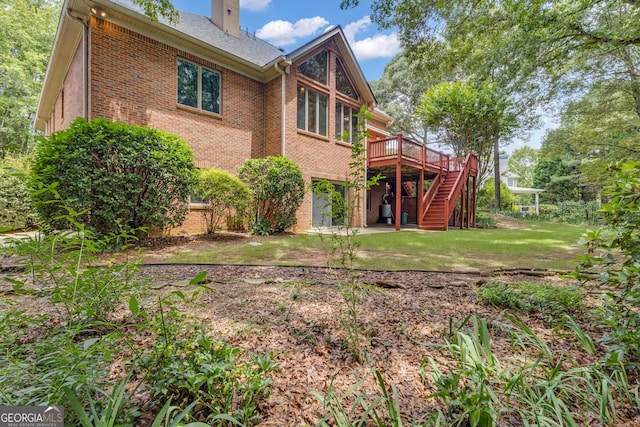 821 Carnellian Ln, Peachtree City, GA 30269 - back of property with brick siding, stairway, a wooden deck, a chimney, and a yard