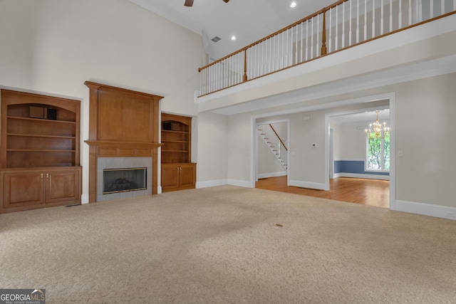 821 Carnellian Ln, Peachtree City, GA 30269 - unfurnished living room with carpet flooring, a towering ceiling, stairs, a tiled fireplace, and ceiling fan