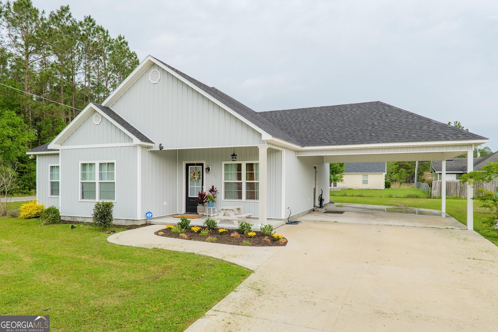 118 Oklahoma Cir, Adel, GA 31620 - view of front facade featuring driveway, a front yard, roof with shingles, and covered porch
