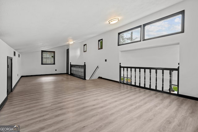 50 Hearthstone Dr, Newnan, GA 30263 - unfurnished living room with wood finished floors, healthy amount of natural light, and vaulted ceiling