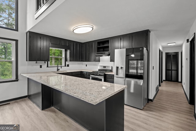 50 Hearthstone Dr, Newnan, GA 30263 - kitchen featuring stainless steel appliances, a peninsula, dark cabinets, light wood-style flooring, and open shelves