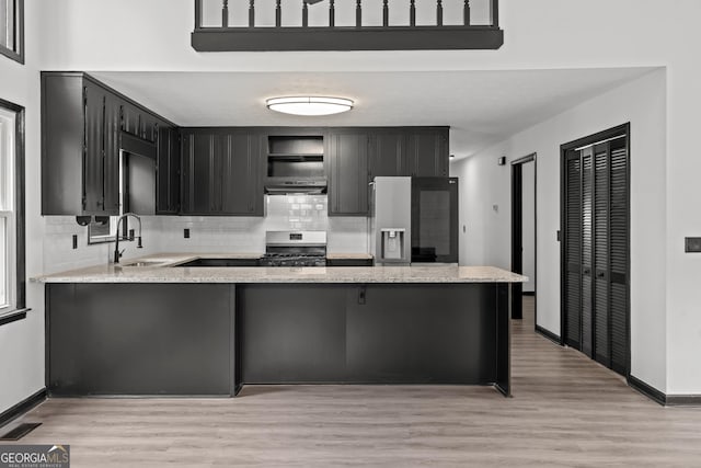 50 Hearthstone Dr, Newnan, GA 30263 - kitchen featuring fridge with ice dispenser, gas range oven, a peninsula, open shelves, and tasteful backsplash