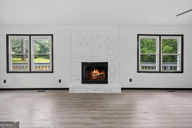 50 Hearthstone Dr, Newnan, GA 30263 - unfurnished living room featuring wood finished floors, a fireplace, and plenty of natural light