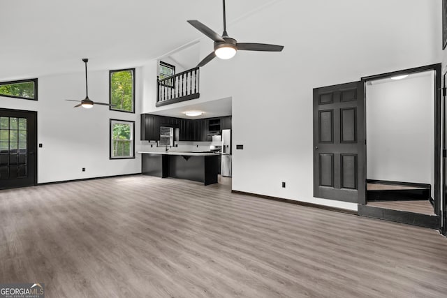 50 Hearthstone Dr, Newnan, GA 30263 - unfurnished living room with ceiling fan, high vaulted ceiling, and light wood-type flooring