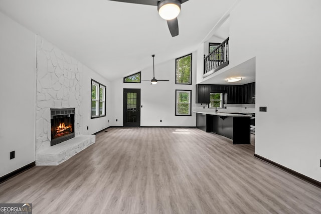 50 Hearthstone Dr, Newnan, GA 30263 - unfurnished living room featuring a ceiling fan, a stone fireplace, high vaulted ceiling, and light wood finished floors