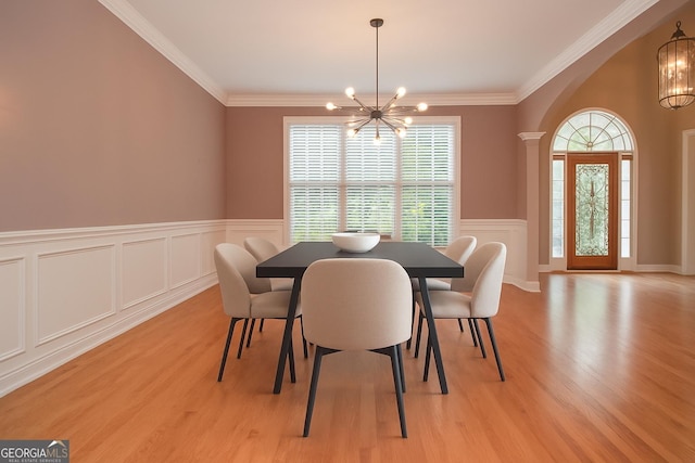 128 Laurel Ridge Dr, Alpharetta, GA 30004 - dining area with a chandelier, arched walkways, light wood-style floors, a decorative wall, and crown molding