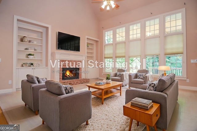 128 Laurel Ridge Dr, Alpharetta, GA 30004 - living area with built in features, ceiling fan, light wood finished floors, high vaulted ceiling, and a brick fireplace