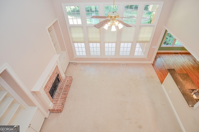 128 Laurel Ridge Dr, Alpharetta, GA 30004 - unfurnished living room with plenty of natural light, a ceiling fan, a towering ceiling, and a brick fireplace