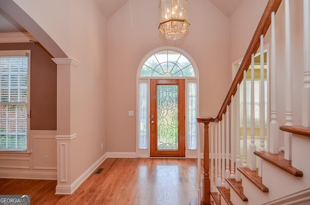 128 Laurel Ridge Dr, Alpharetta, GA 30004 - entrance foyer with stairway, a chandelier, wood finished floors, high vaulted ceiling, and a wainscoted wall