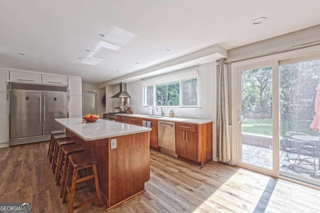 1908 Musket Ct, Stone Mountain, GA 30087 - kitchen with high quality appliances, light wood-type flooring, brown cabinets, and a breakfast bar area