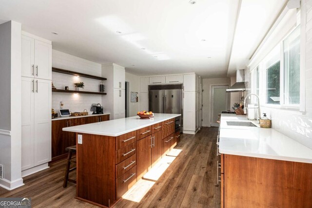 1908 Musket Ct, Stone Mountain, GA 30087 - kitchen with wall chimney range hood, a center island, high end fridge, and dark wood-style floors