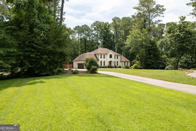 1908 Musket Ct, Stone Mountain, GA 30087 - view of front facade with concrete driveway, an attached garage, and a front yard