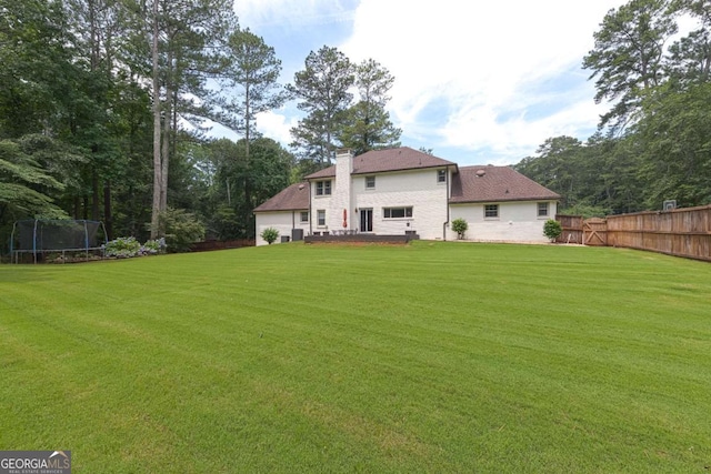1908 Musket Ct, Stone Mountain, GA 30087 - rear view of house with a trampoline and a chimney