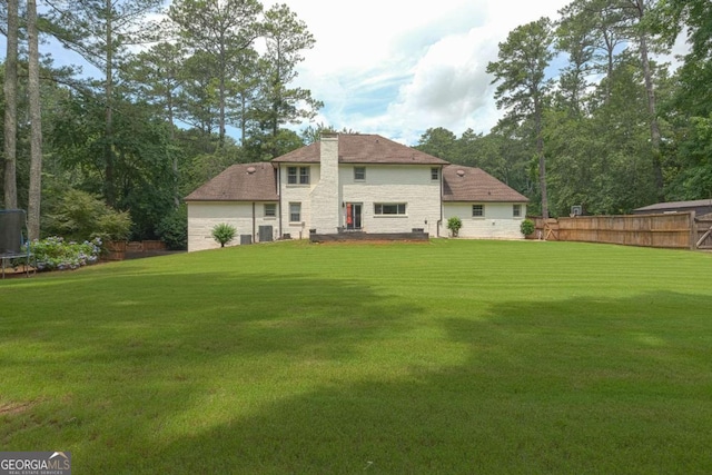1908 Musket Ct, Stone Mountain, GA 30087 - back of property with a trampoline, a chimney, and stone siding