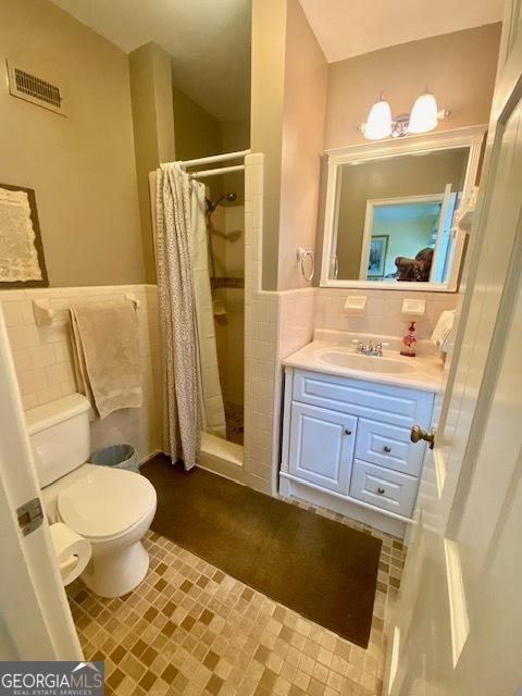 1812 Morgan Cantey Dr, Lanett, AL 36863 - full bathroom with tile walls, a stall shower, vanity, and wainscoting