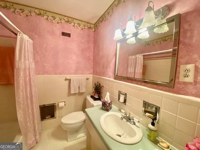 1812 Morgan Cantey Dr, Lanett, AL 36863 - bathroom featuring vanity, tile walls, a wainscoted wall, and wallpapered walls