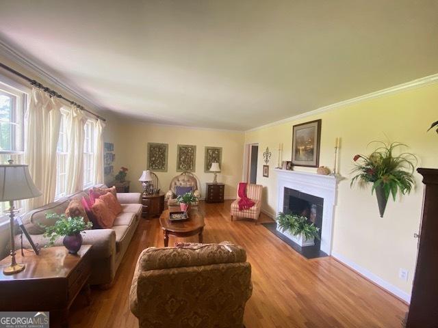 1812 Morgan Cantey Dr, Lanett, AL 36863 - living room featuring a fireplace with flush hearth, wood finished floors, and ornamental molding