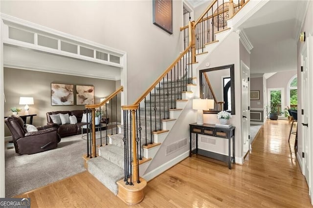 4300 May Apple Dr, Alpharetta, GA 30005 - stairs with wood finished floors, crown molding, and a towering ceiling