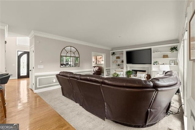4300 May Apple Dr, Alpharetta, GA 30005 - living room featuring ornamental molding, light wood-style flooring, built in features, a fireplace, and a wainscoted wall