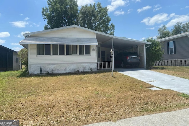435 Village Cir SW, Winter Haven, FL 33880 - manufactured / mobile home featuring driveway, a front lawn, and an attached carport