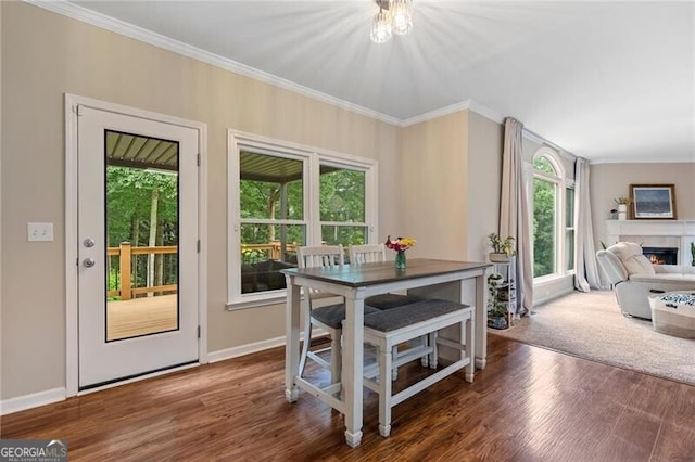 2772 Hillgrove Dr, Dacula, GA 30019 - dining room with ornamental molding, wood finished floors, and a lit fireplace